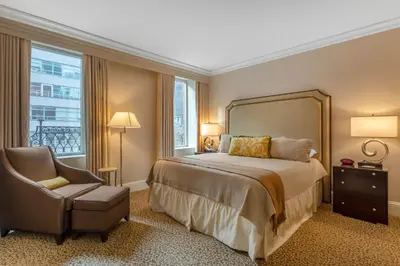 a bedroom with a large bed and a chair at Omni Berkshire Place in New York