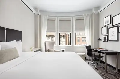a bedroom with a large white bed and a desk at The Gregorian New York City in New York