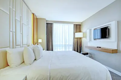 a hotel room with a large white bed and a tv at Club Wyndham Midtown 45 in New York