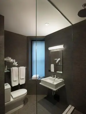 a bathroom with a sink and a toilet and a mirror at AKA Times Square in New York