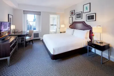a bedroom with a bed and a desk and a television at The Lexington Hotel, Autograph Collection in New York