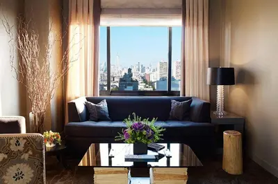 a living room with a blue couch and a window at Soho Grand Hotel in New York