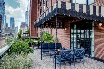 a patio with chairs and tables on a brick building at Soho Grand Hotel in New York