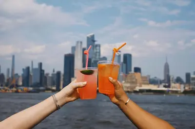 two people holding up two drinks in their hands at Sheraton Lincoln Harbor Hotel in Weehawken