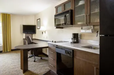 a kitchen with a sink and a desk in a room at Candlewood Suites Windsor Locks by IHG in Windsor Locks