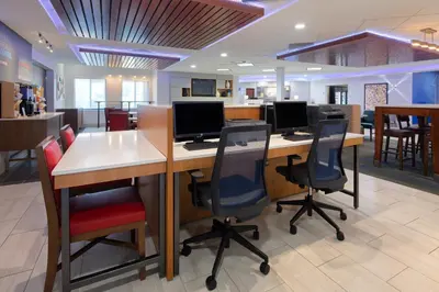 an office with a desk with two computer monitors on it at Holiday Inn Express & Suites Bradley Airport by IHG in Windsor Locks