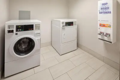 a laundry room with a washing machine and a washer at Holiday Inn Express & Suites Bradley Airport by IHG in Windsor Locks