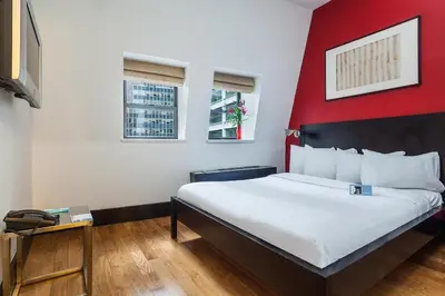 a bedroom with a large bed with a red wall at Eurostars Wall Street in New York