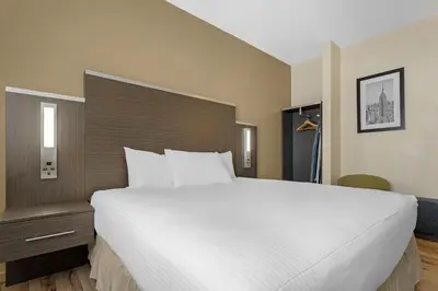 a large white bed in a hotel room at Best Western Jamaica Inn in Queens