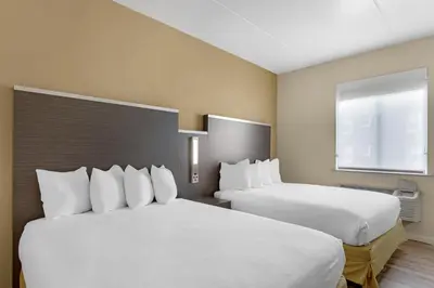 a hotel room with two beds and a window at Best Western Jamaica Inn in Queens