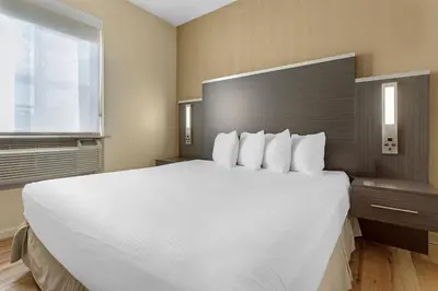 a large white bed in a room with a window at Best Western Jamaica Inn in Queens
