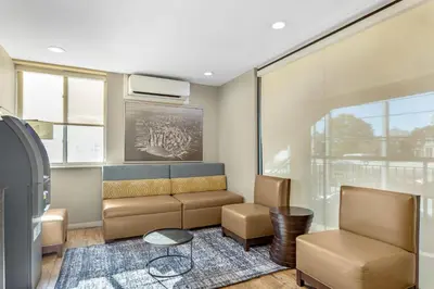 a living room with a couch and two chairs at Best Western Jamaica Inn in Queens