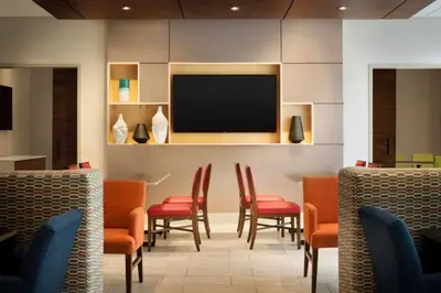 a waiting room with chairs and a flat screen tv at Holiday Inn Express & Suites - Middletown - Goshen by IHG in Middletown