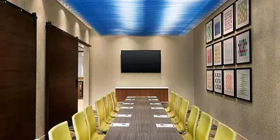 a conference room with a long table and yellow chairs at Holiday Inn Express & Suites - Middletown - Goshen by IHG in Middletown