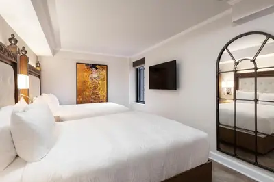 a white bedroom with two beds and a tv at Westgate New York Grand Central in New York