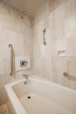 a white bath tub in a bathroom with tiles at Westgate New York Grand Central in New York