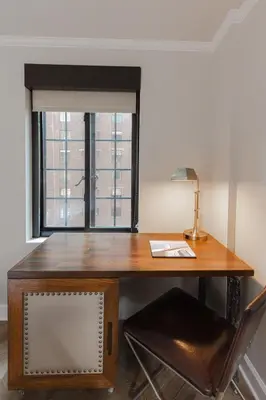 a wooden desk with a lamp and a window at Westgate New York Grand Central in New York