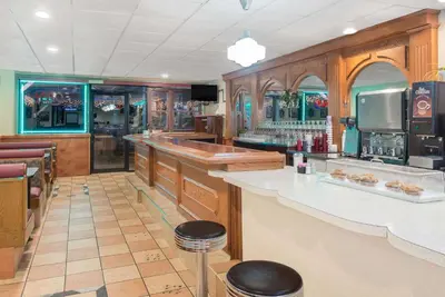 a restaurant with a counter and a bar with stools at Howard Johnson by Wyndham Saugerties in Saugerties