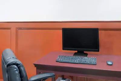 a desk with a computer monitor and a keyboard and mouse at Howard Johnson by Wyndham Saugerties in Saugerties