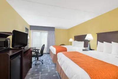 a hotel room with two beds and a flat screen tv at Howard Johnson by Wyndham Saugerties in Saugerties