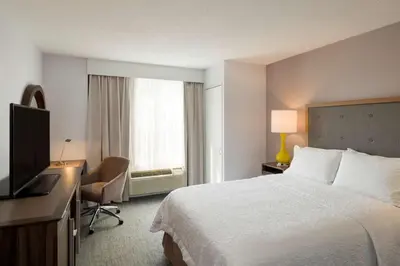 a hotel room with a bed and a desk and a television at Hampton Inn Manhattan Chelsea in New York