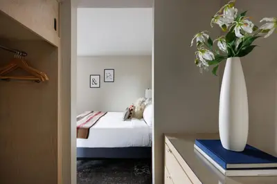 a bedroom with a bed and a vase with flowers at The Andrew Hotel in Great Neck