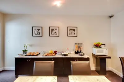 a kitchen with a table with food and a microwave at The Andrew Hotel in Great Neck