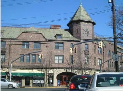 a large brick building with a tower on top of it at The Andrew Hotel in Great Neck