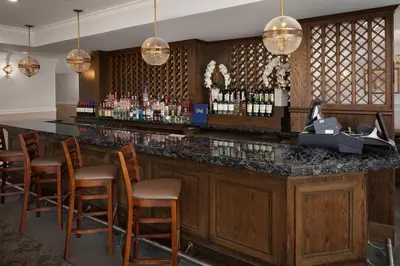 a bar at a hotel with chairs and lights at The Andrew Hotel in Great Neck