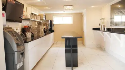 a kitchen with a table in the middle of a room at Super 8 by Wyndham North Bergen NJ/NYC Area in North Bergen