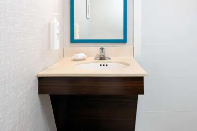 a bathroom with a sink and a mirror at Hampton Inn Hartford Airport in Windsor Locks