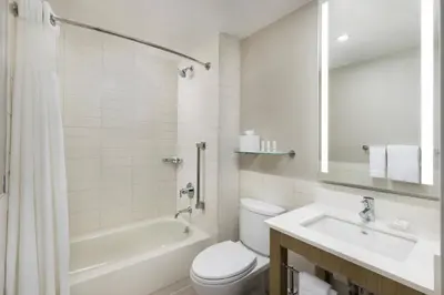 a white bathroom with a tub and a toilet and a sink at Courtyard New York Downtown Manhattan/Financial District in New York