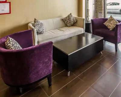 a living room with a couch and two chairs at Rodeway Inn Bronx Zoo in Bronx