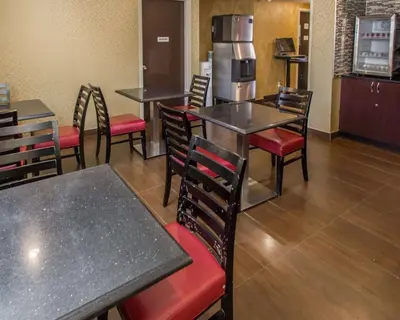 a restaurant with tables and chairs and a refrigerator at Rodeway Inn Bronx Zoo in Bronx