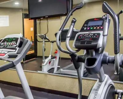 a gym with several exercise bikes and a mirror at Rodeway Inn Bronx Zoo in Bronx