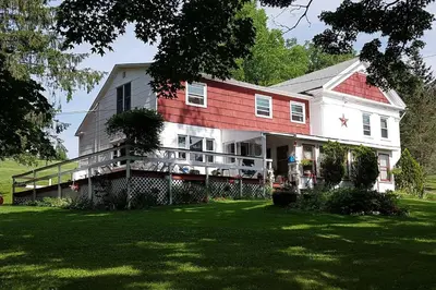 a large house with a red roof on a lawn at The Open Door in Jefferson NY in Jefferson