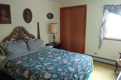 a bedroom with a bed with a blue comforter at The Open Door in Jefferson NY in Jefferson