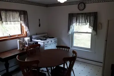 a kitchen with a table and a stove and window at The Open Door in Jefferson NY in Jefferson