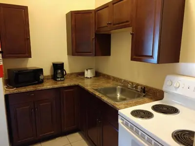 a kitchen with wooden cabinets and a sink and a stove at Hotel Wayne in Honesdale