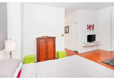 a white bedroom with a bed and a tv at great studio apt new york city in New York