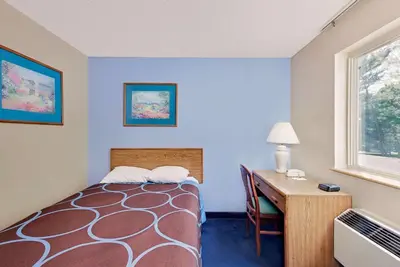 a room with a bed and a desk and a window at Super 8 by Wyndham Newburgh/West Point Stewart Intl Airport in Newburgh