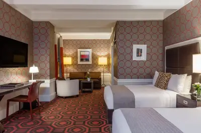 a hotel room with two beds and a desk at The Empire Hotel New York in New York