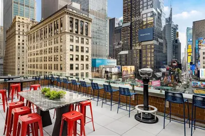 a table and chairs on the roof of a building at M Social Hotel New York Times Square in New York