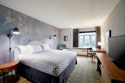 a hotel room with a bed and a television at Tarrytown House Estate in Tarrytown