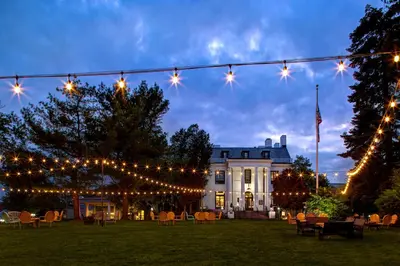 a string of lights in front of a white house at Tarrytown House Estate in Tarrytown