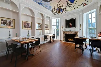 a room with tables and chairs and a fireplace at Tarrytown House Estate in Tarrytown