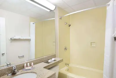 a bathroom with a sink and a large mirror at Howard Johnson by Wyndham Newburgh in Newburgh