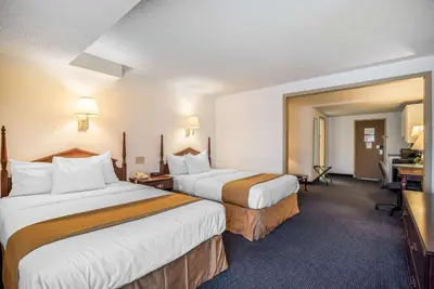 a hotel room with two beds and a desk at Quality Inn & Suites Albany Airport in Latham