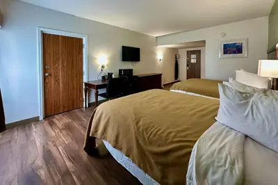 a hotel room with two beds and a desk at Quality Inn & Suites Albany Airport in Latham