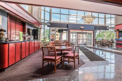 a restaurant with a table and chairs and a chandelier at Quality Inn & Suites Albany Airport in Latham